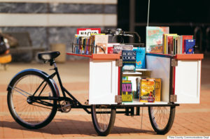 Photo of Pima County's first Book Bike on January 30, 2012 at the Joel D. Valdez Main Library. The modified cargo bike, made by Haley Tricycles in Philadelphia, is outfitted with book shelves. Donated books will be given away during appearances.